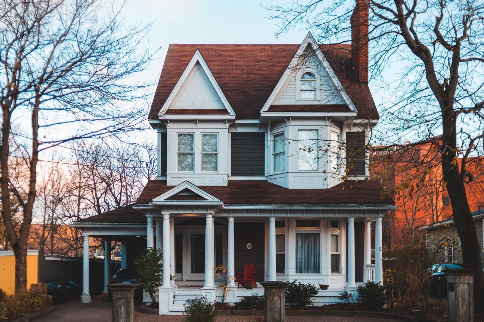Victorian house with a wide front porch among bare trees, the kind of home movers in Cranston, RI handle every week