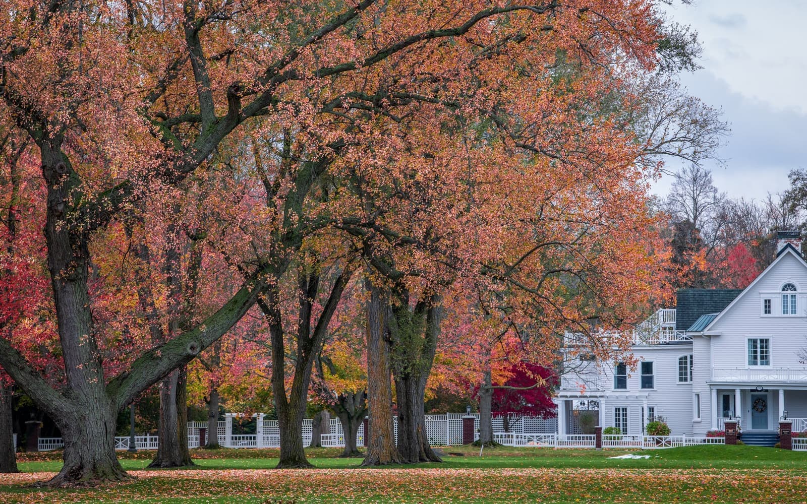 White Victorian house behind red autumn trees and a lawn, the kind of home movers in Lincoln, RI handle every week